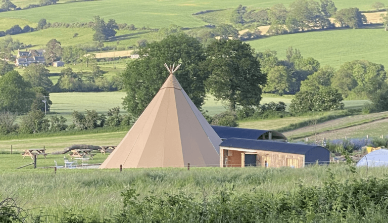 An exterior view of a teepee tent at the Story Pig in Dorset